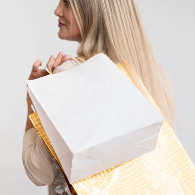 Close-up elegant woman carrying shopping bags