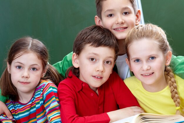 Close-up of elementary students with an open book