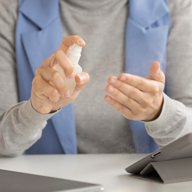 Close-up employee disinfecting hands