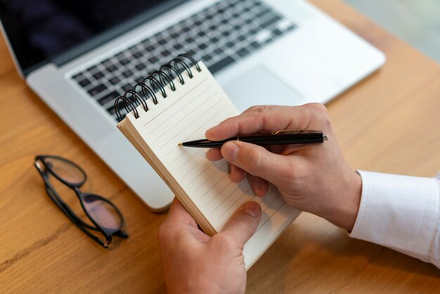 Close up employee writing in notepad