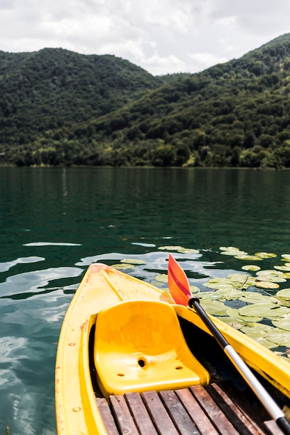 山の近くの湖の空のカヌーのクローズアップ