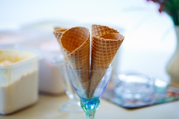 Закрыть пустой вафельный рожок в стакане для мороженого Вкусные и сладкие формы для мороженого в кафе на баре идеально подходят для летней жары Концепция еды и пустыни