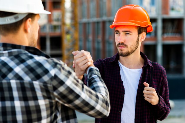 Close-up of engineer and architect  shaking hands