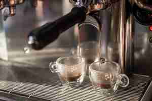 Free photo close-up espresso pouring into cups