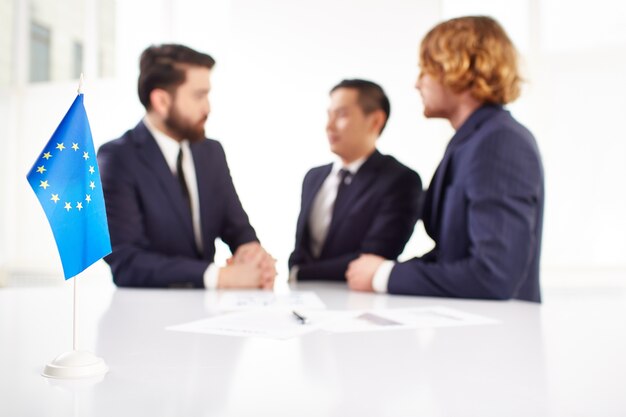 Close-up of europe flag with businessmen background