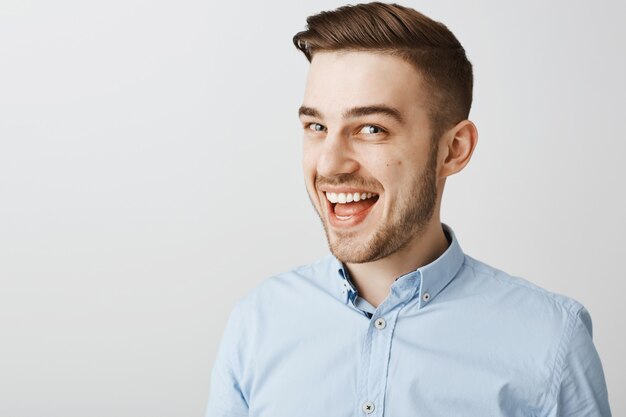 Close-up of excited happy man hear great news, smiling upbeat