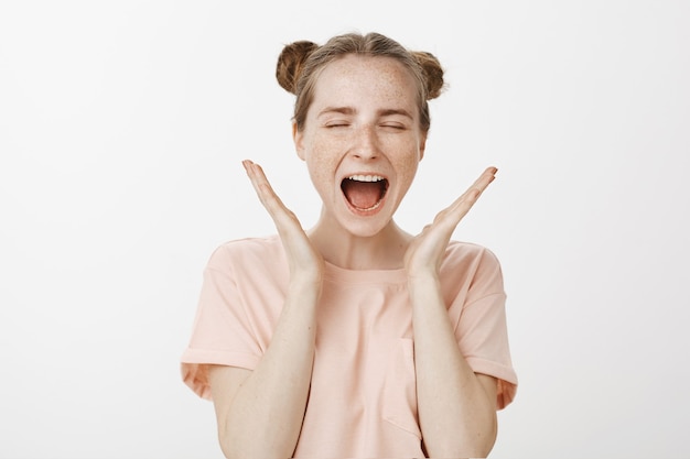 Free photo close-up of excited teenage girl posing against the white wall