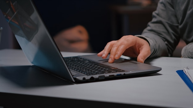 Close-up of executive man hands answering negotiations email planning business company consultation late at night in startup office