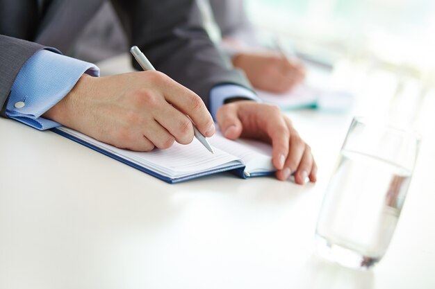 Close-up of executive writing with a pen