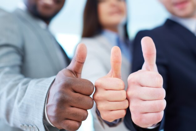 Close-up of executives showing thumbs up