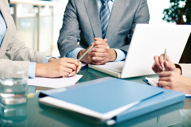 Close-up of executives sitting at the table