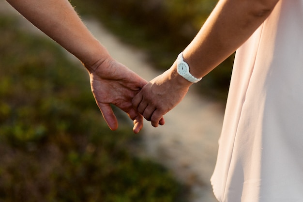 Close-up of expecting couple's hands holding each other tender 