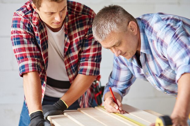 Close up on experienced carpenter and his younger employee