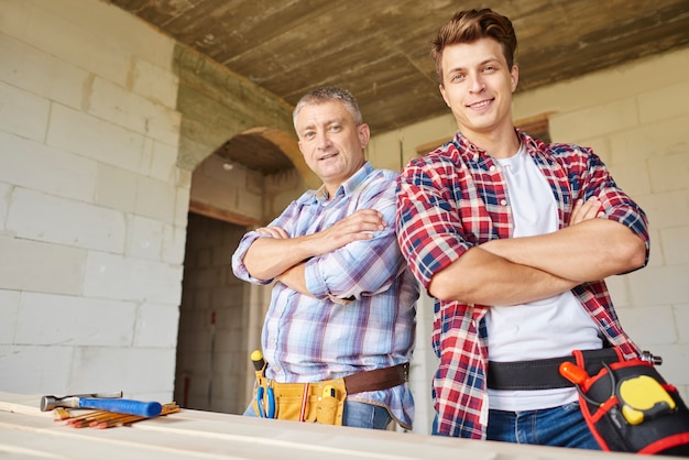 Free photo close up on experienced carpenter and his younger employee