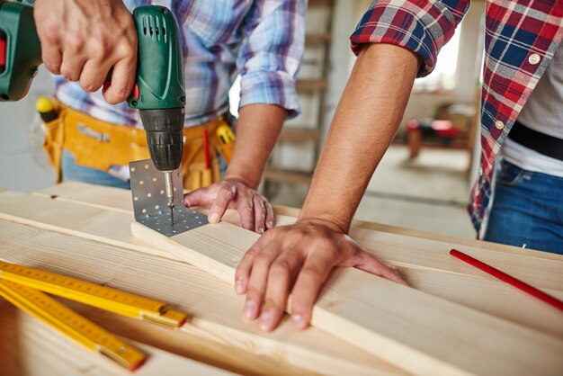 Close up on experienced carpenter and his younger employee