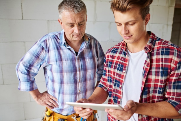 Close up on experienced carpenter and his younger employee