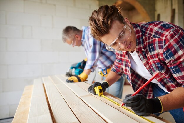 Close up on experienced carpenter and his younger employee