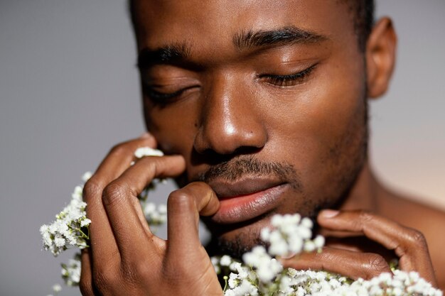 Close-up expressive man smelling flowers