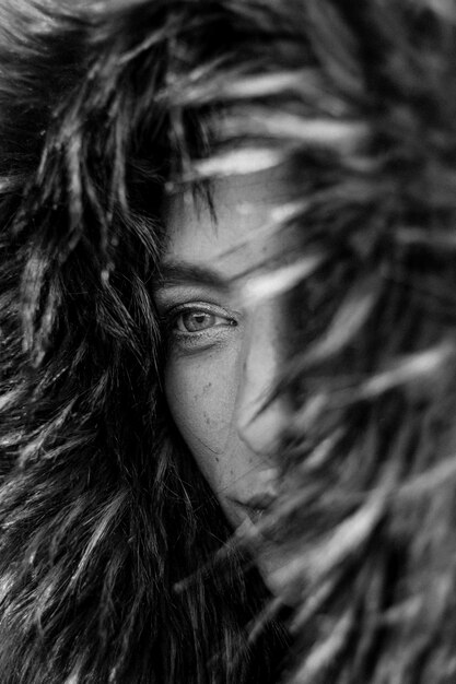 Close up on eyes of a pretty young woman in a big fur coat