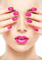 Foto gratuita fronte del primo piano di una bella ragazza con unghie e labbra rosa brillante.