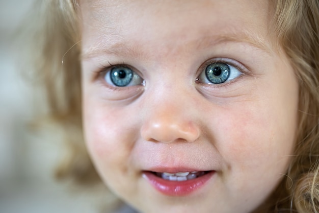 큰 파란 눈을 가진 작은 귀여운 소녀의 클로즈업 얼굴.