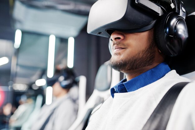 Close up face of man Two young indian people having fun with a new technology of a vr headset at virtual reality simulator