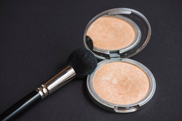 मुफ़्त फोटो close-up of face powder and brush on black backdrop