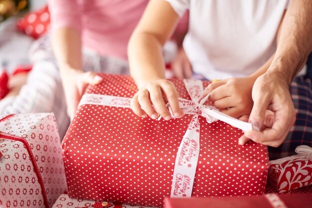 Close up of family hands during opening Christmas presents