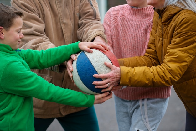 Close up family members holding ball