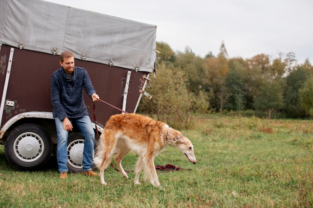 Free photo close up on farmer spending time with dog