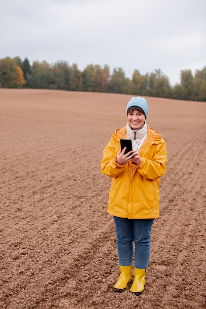 Foto gratuita primo piano sull'agricoltore che utilizza un dispositivo digitale