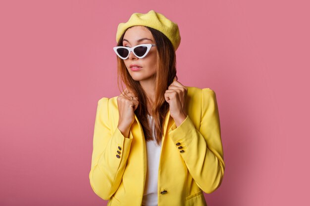 Close up fashion portrait of stylish woman in yellow suit and beret.