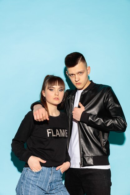 Close up fashion portrait of two young cool hipster girl and boy wearing jeans wear