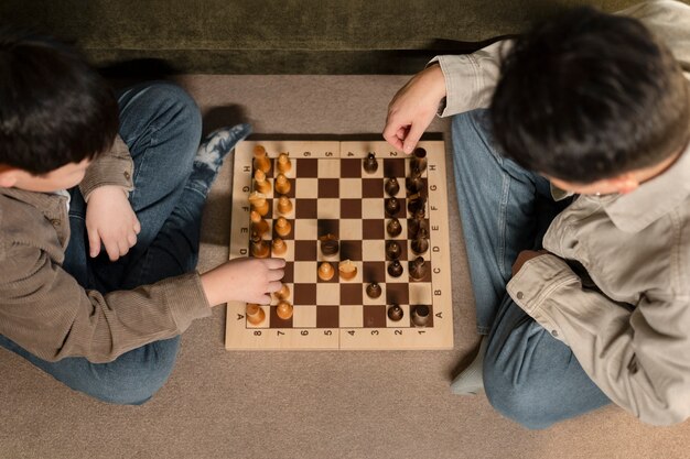 Close up father and boy playing chess