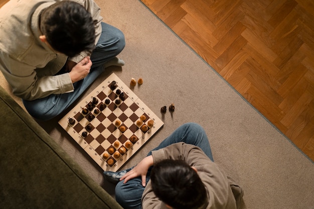 Close up father and boy playing chess