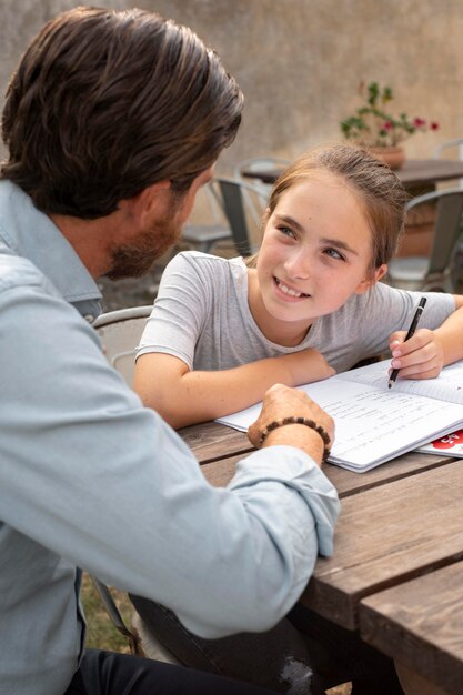 Крупным планом отец помогает ребенку с домашним заданием