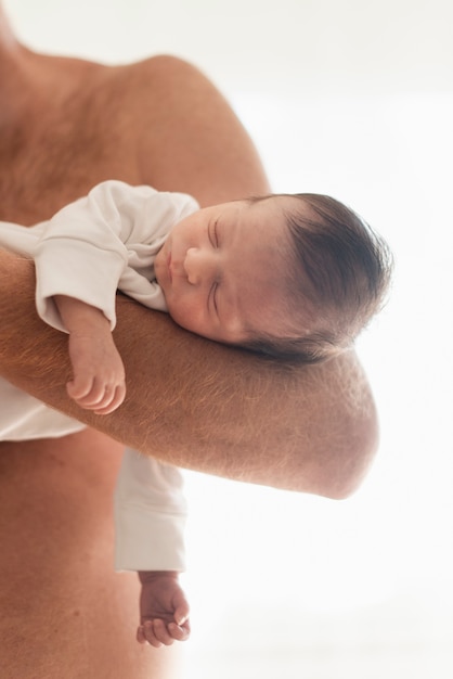 Foto gratuita figlio addormentato della tenuta del padre del primo piano