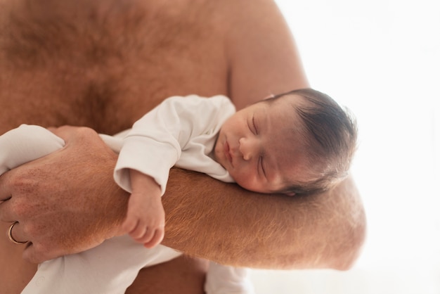 Free photo close-up father holding sleepy baby