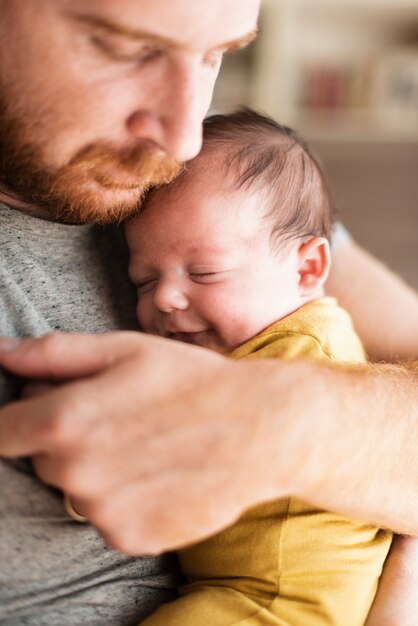 Close-up father holding small baby