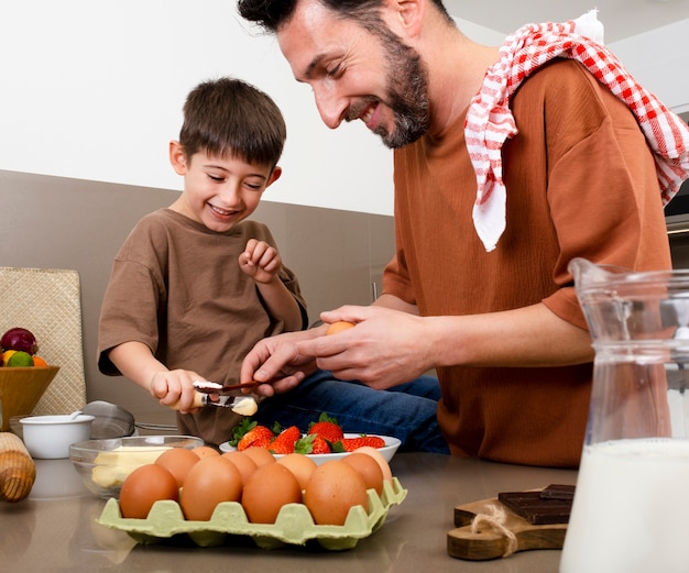 Close up father and kid cooking together