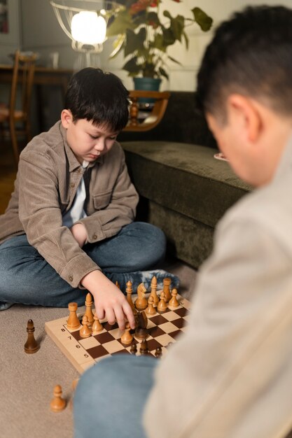 Close up father and kid playing chess