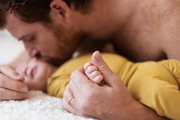 Foto gratuita padre del primo piano che bacia bambino assonnato