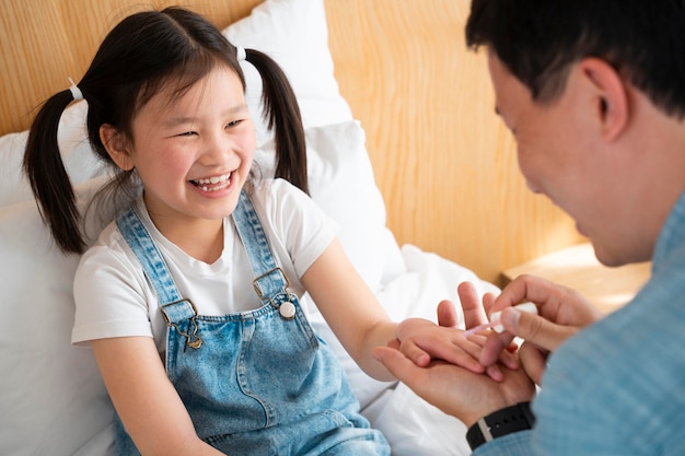 Close up father painting girl's nails