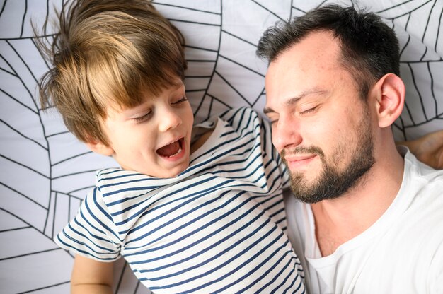 Close-up father and son in bed