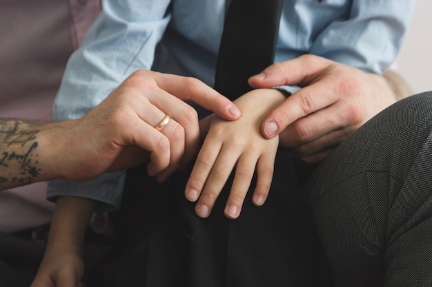 Close-up of father stroking his son's hand