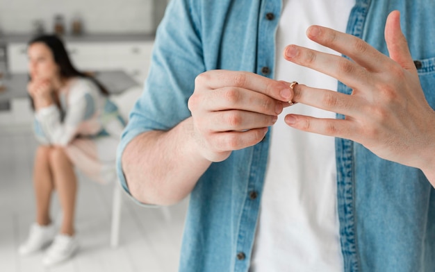 Close-up father taking wedding ring off