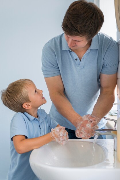 クローズアップの父が息子に手を洗う方法を教える