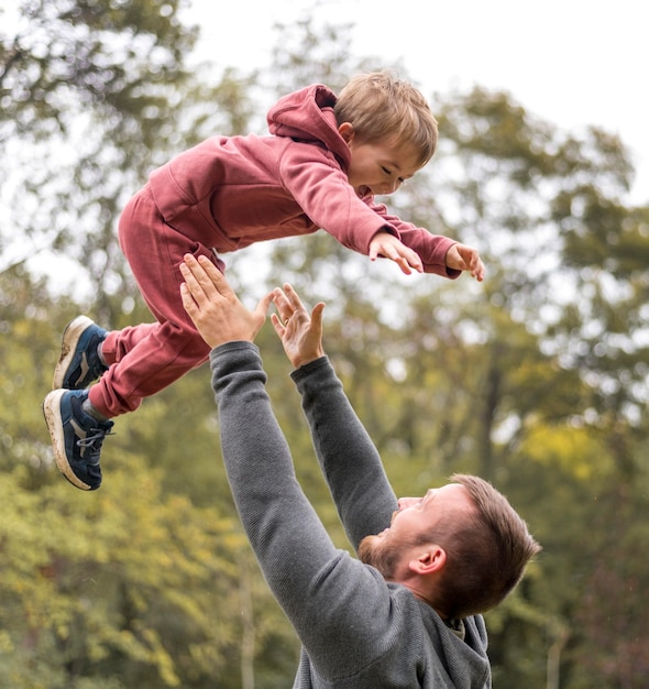 Free photo close-up father throwing son up