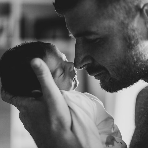 Close-up father touching baby with his nose