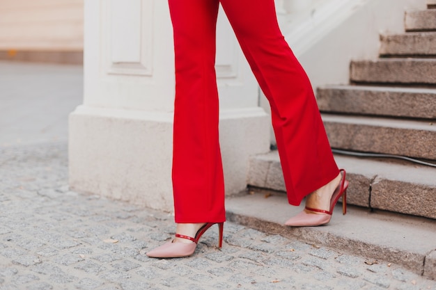 Foto gratuita chiudere i piedi in scarpe sui tacchi della donna di stile business ricco sexy bella in vestito rosso che cammina nella via della città, tendenza moda primavera estate